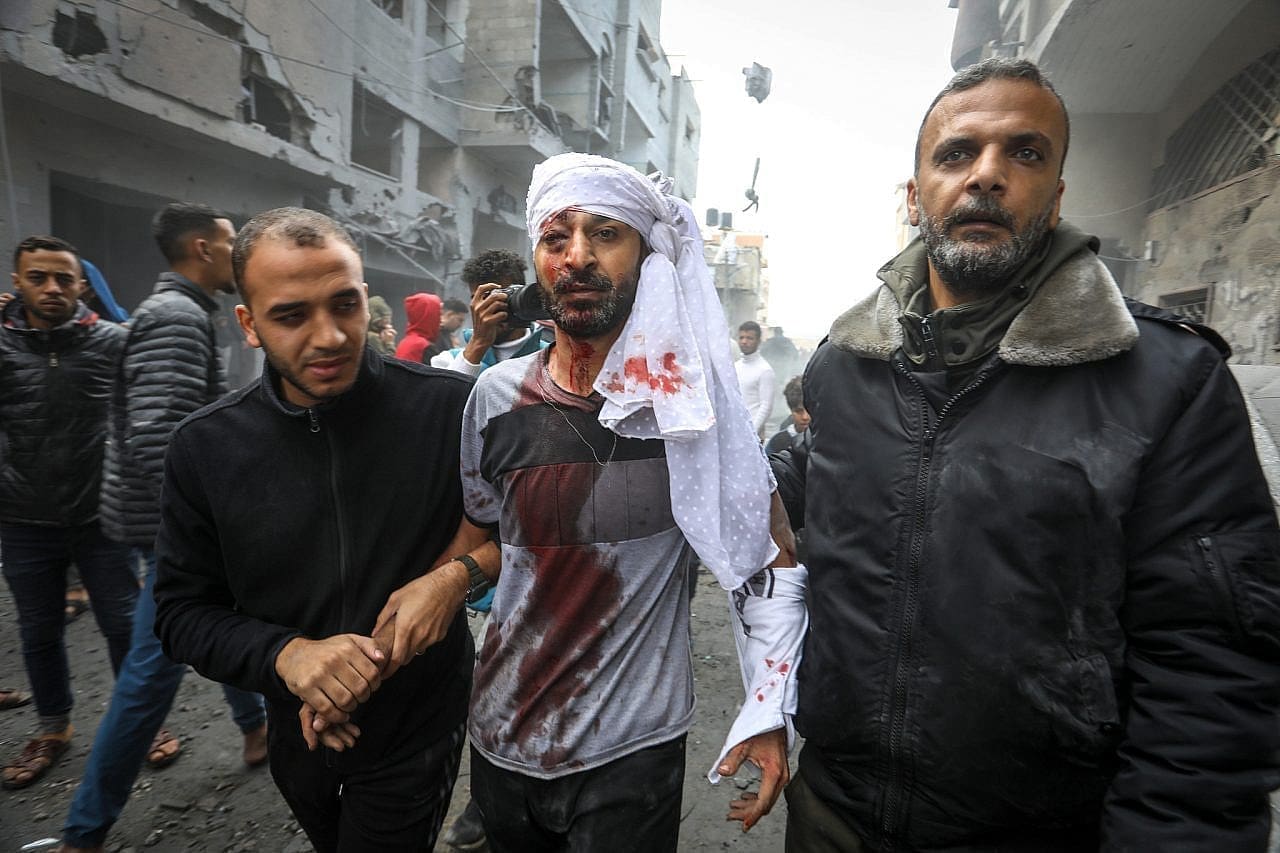 Palestinians emerge from the rubble of houses destroyed in Israeli airstrikes in the city of Rafah