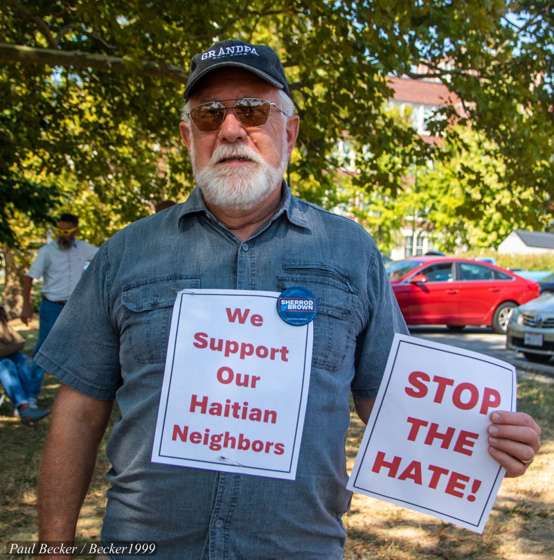 Racism in eating dogs trope: A man in Springfield, Ohio holds a sign that he respects and supports the Haitian immigrants in town.