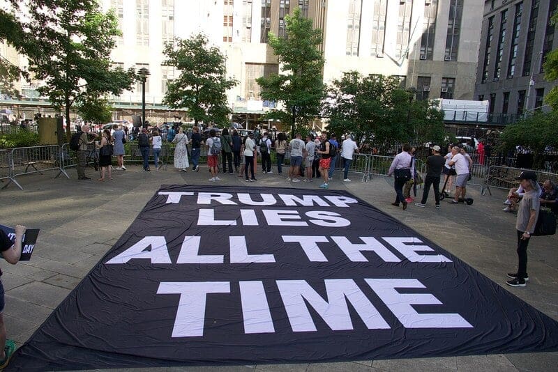 Facts matter The trial is getting busy this Tuesday, for what may be the final or the second-to-last week. Anti-Trump demonstrators unfurled a large banner on the ground of the park, after the pro-Trump demonstrators have left, saying "Trump lies all the time".