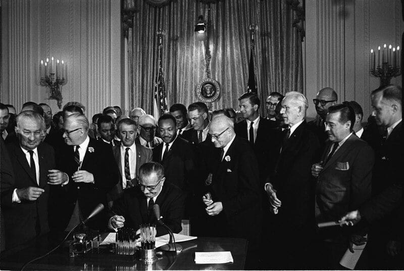 Systemic racism President Lyndon B. Johnson signs the 1964 Civil Rights Act as Martin Luther King, Jr., and others, look on.